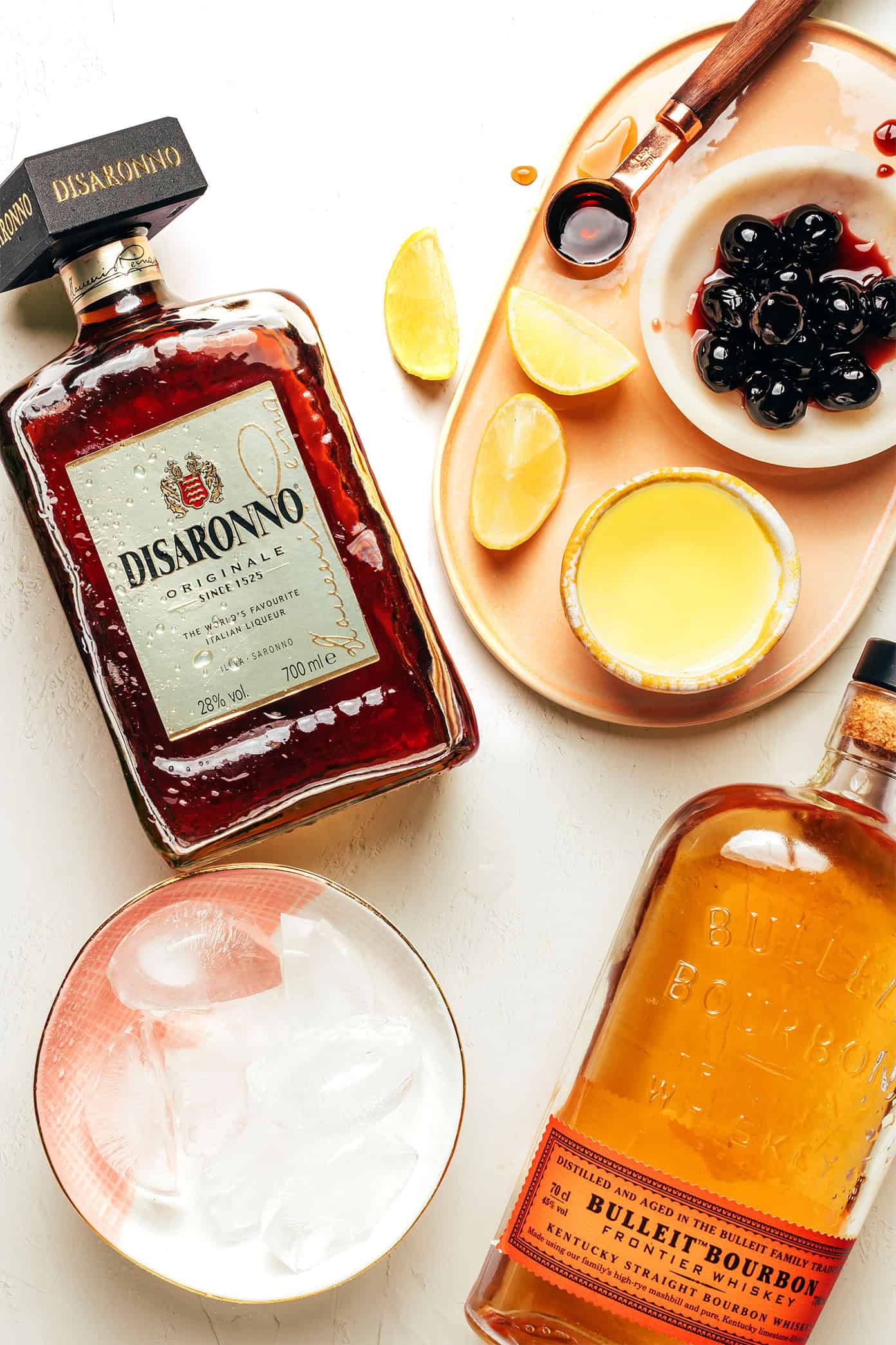 This classic Amaretto Sour recipe is easy to make with bourbon, lemon juice, Amaretto and egg white. Feel free to add additional sweetener or bitters, if you'd like, and garnish with a lemon twist and maraschino cherry. It's always such a cozy and sophisticated cocktail! | gimmesomeoven.com Amaretto Sour Ingredients