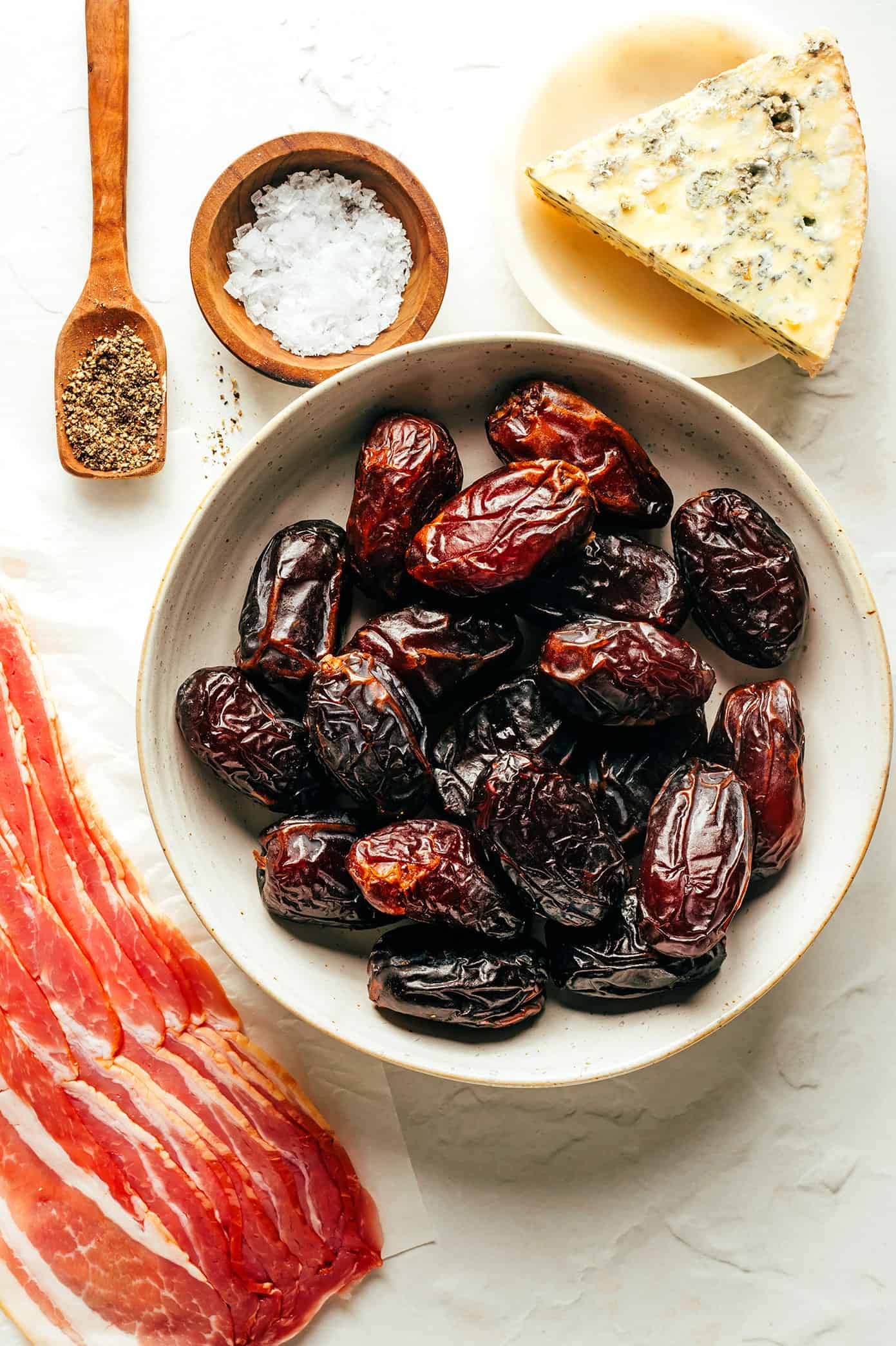 My favorite bacon-wrapped dates recipe is made with crispy bacon, tender Medjool dates, and stuffed with your choice of cheese (blue, feta, goat, cheddar, etc). A delicious appetizer that's easy to make and always a party favorite! | gimmesomeoven.com Bacon Wrapped Dates Ingredients
