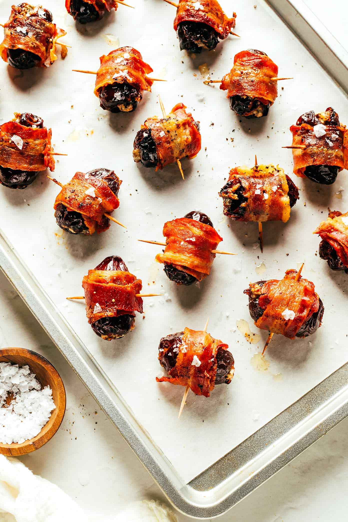 My favorite bacon-wrapped dates recipe is made with crispy bacon, tender Medjool dates, and stuffed with your choice of cheese (blue, feta, goat, cheddar, etc). A delicious appetizer that's easy to make and always a party favorite! | gimmesomeoven.com Bacon Wrapped Dates with Blue Cheese on Sheet Pan