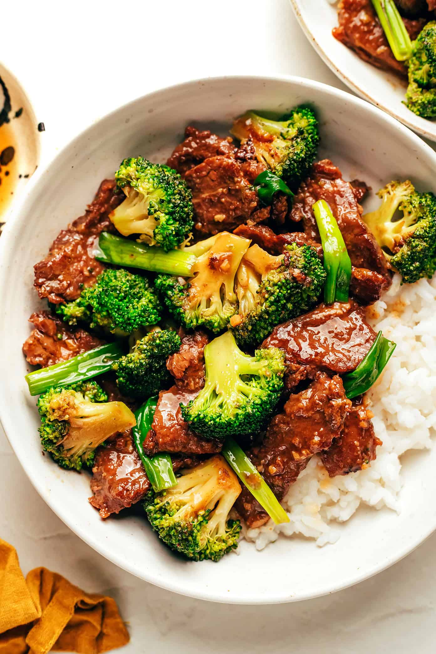 This easy beef and broccoli stir-fry features tender steak, crisp broccoli, and a bold, garlicky sauce โ all ready in just 30 minutes. beef and broccoli served over rice in bowl