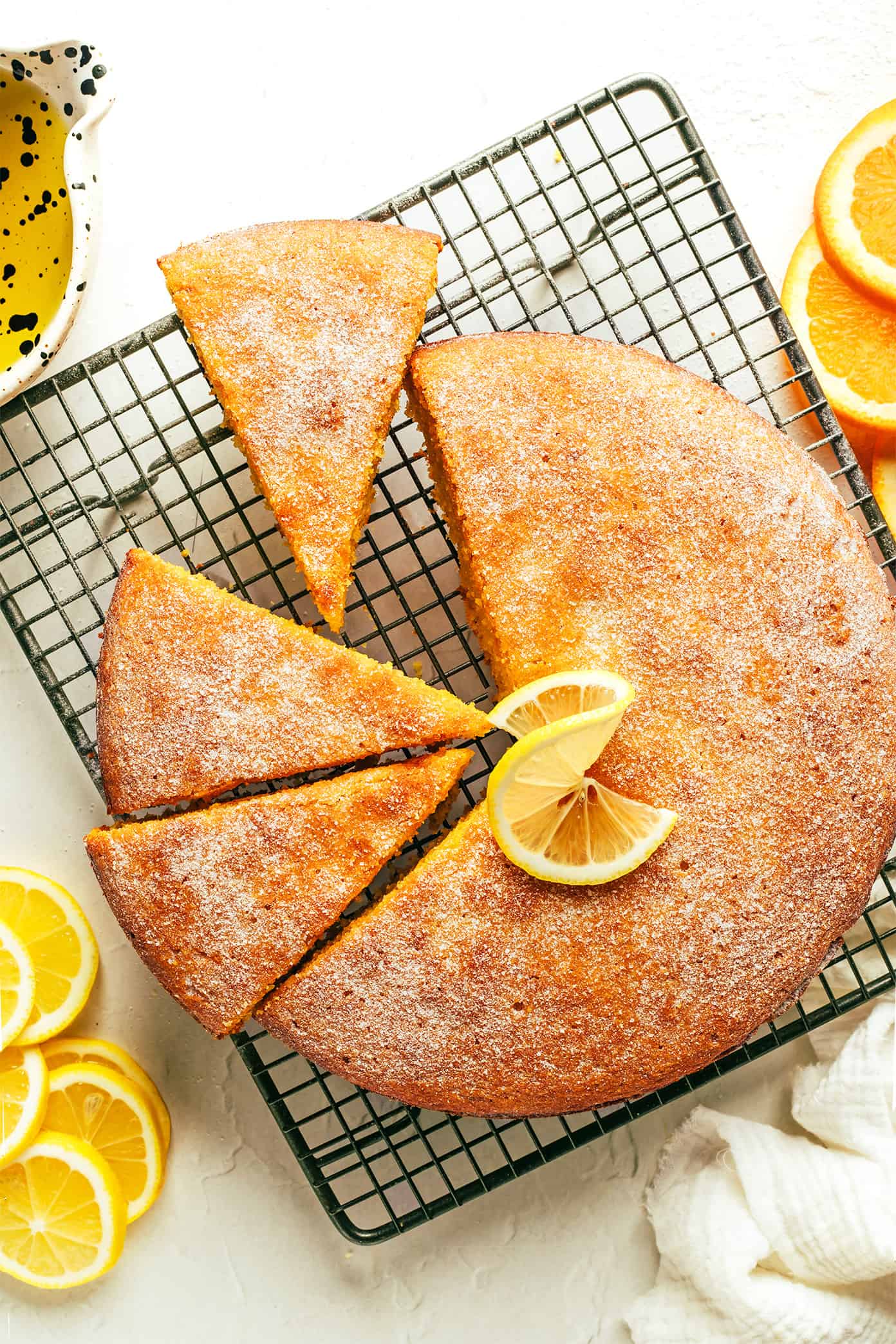 This citrus olive oil cake recipe is easy to make in one bowl, naturally gluten-free and dairy-free, lightly sweetened, and made with the loveliest hints of fresh orange and lemon. Perfect for dessert, snacking or even breakfast and always so delicious. Serve on its own or with whipped cream, ice cream or fruit and enjoy! | gimmesomeoven.com Citrus Olive Oil Cake on Wire Cooling Rack