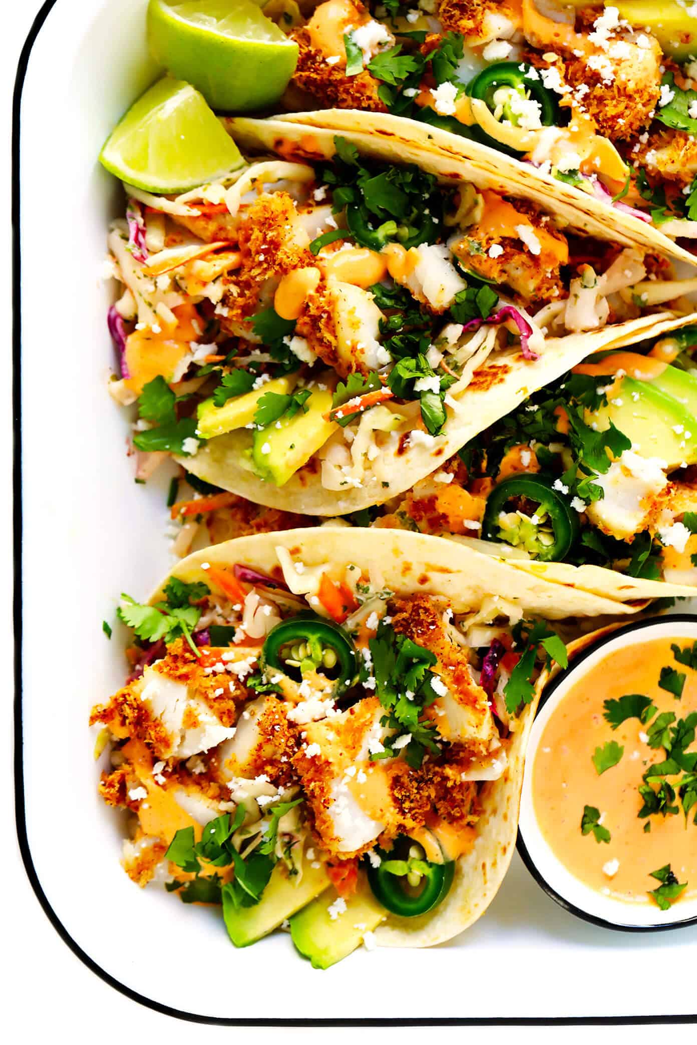 The BEST fish taco recipe!! These fish tacos are made with crispy baked Panko-crusted fish, cilantro lime slaw, chipotle crema, avocado, and whatever other toppings you love most! They're also easy to make gluten-free and dairy-free if you would like, and SO DELICIOUS. | gimmesomeoven.com #fish #tacos #healthy #mexican #dinner #glutenfree