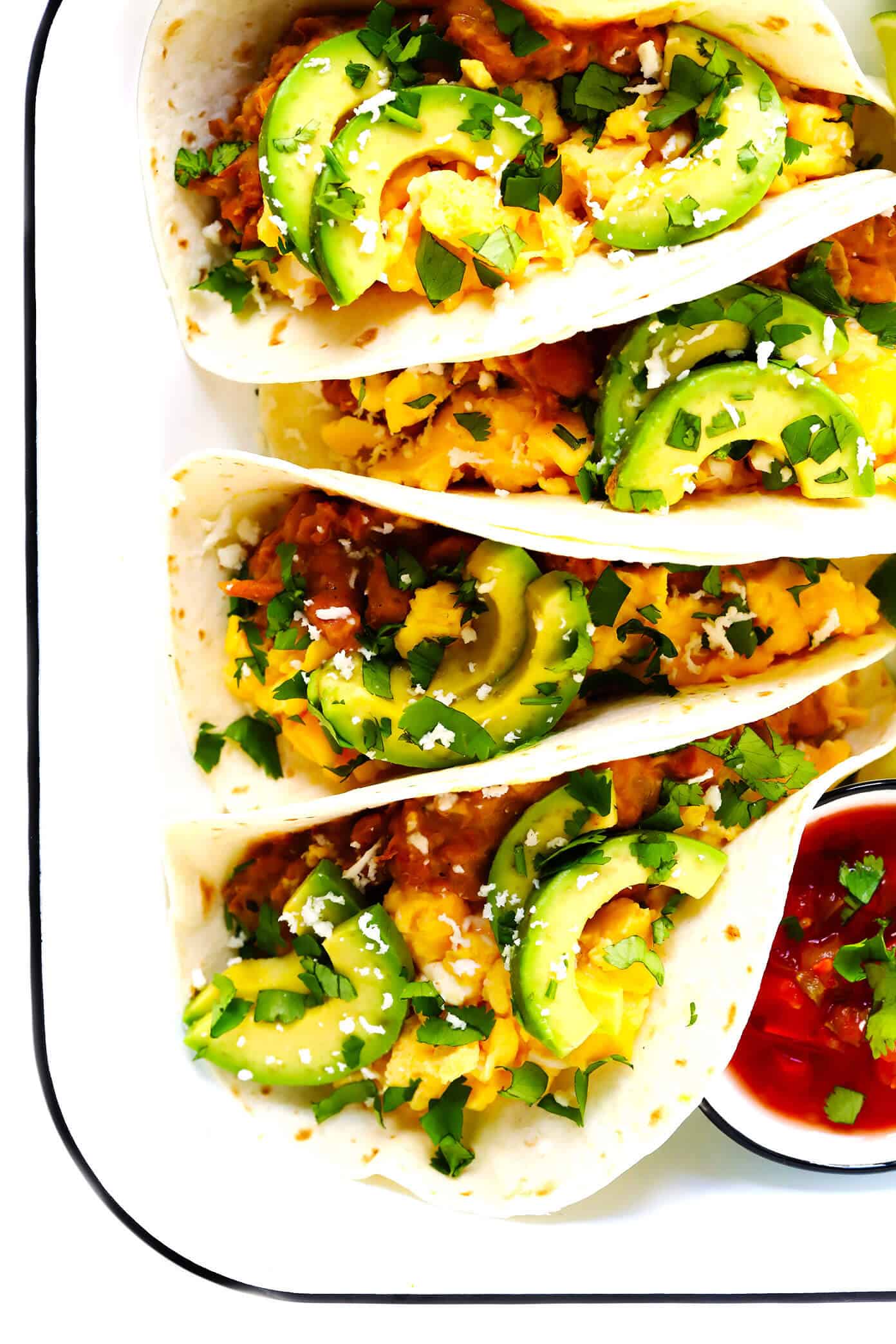 LOVE this easy breakfast tacos recipe! This base recipe simply calls for my favorite homemade refried beans, scrambled (or fried) eggs, avocado, salsa and any other toppings that sound good. Easy to make in about 30 minutes, and so hearty and delicious! | gimmesomeoven.com #breakfast #tacos #mexican #texmex #vegetarian #glutenfree #brunch #healthy Easy Breakfast Tacos