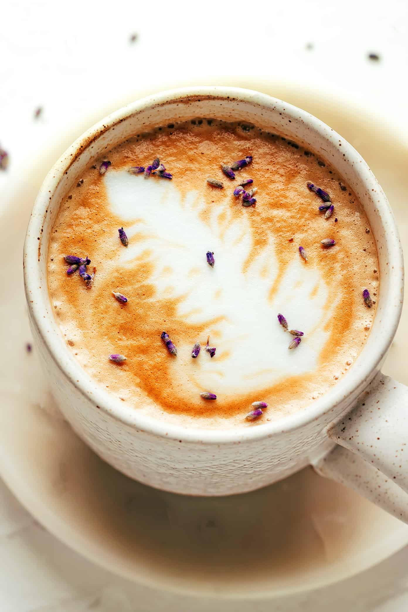 This homemade lavender latte recipe can be made hot or iced and is easy to customize with your favorite milk, espresso and add-ins. So delicious and less expensive than the coffee shop version! | gimmesomeoven.com Lavender Latte in Mug