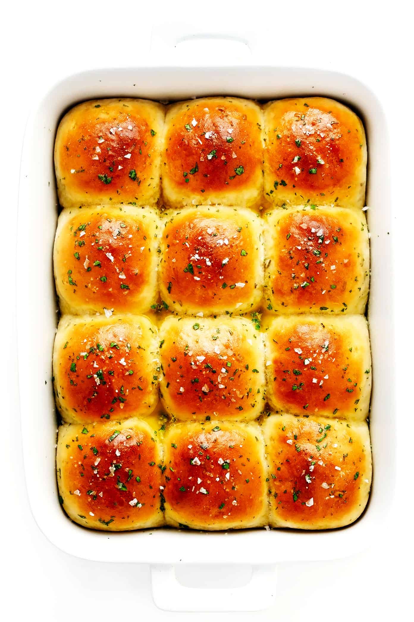 This rosemary garlic dinner rolls recipe is perfectly soft and fluffy, easy to make with or without a stand mixer, brushed with garlic herb butter and sprinkled with flaky sea salt, and ready to go in about one hour! Always a fantastic side dish for holidays like Thanksgiving, or the perfect easy bread recipe for weeknight dinners too. Vegan option included. | gimmesomeoven.com Rosemary Garlic Dinner Rolls in Pan