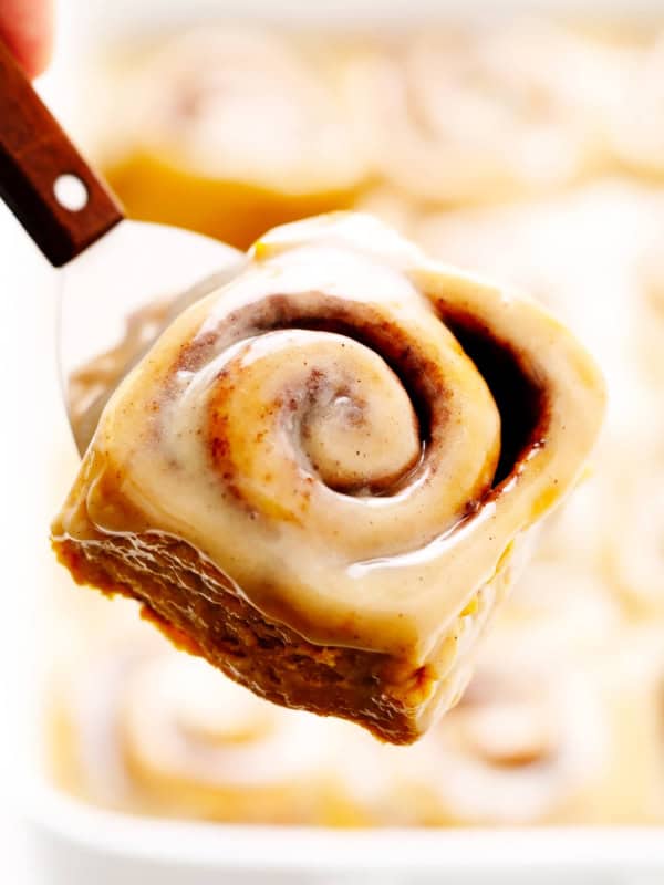 Pumpkin Cinnamon Rolls lifting out of pan