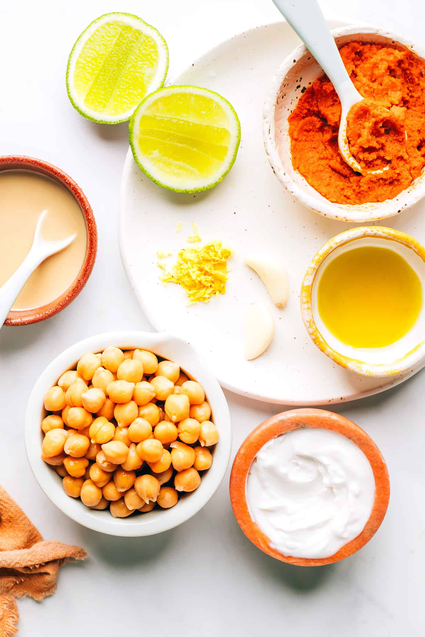 This Thai-inspired red curry hummus recipe is quick and easy to make in just 10 minutes with chickpeas, tahini, coconut milk, curry paste, ginger and garlic. Serve it up as a dip with cruditรฉs and naan, or use it as a spread on burgers or wraps. Such a great easy appetizer! | gimmesomeoven.com Red Curry Hummus Ingredients