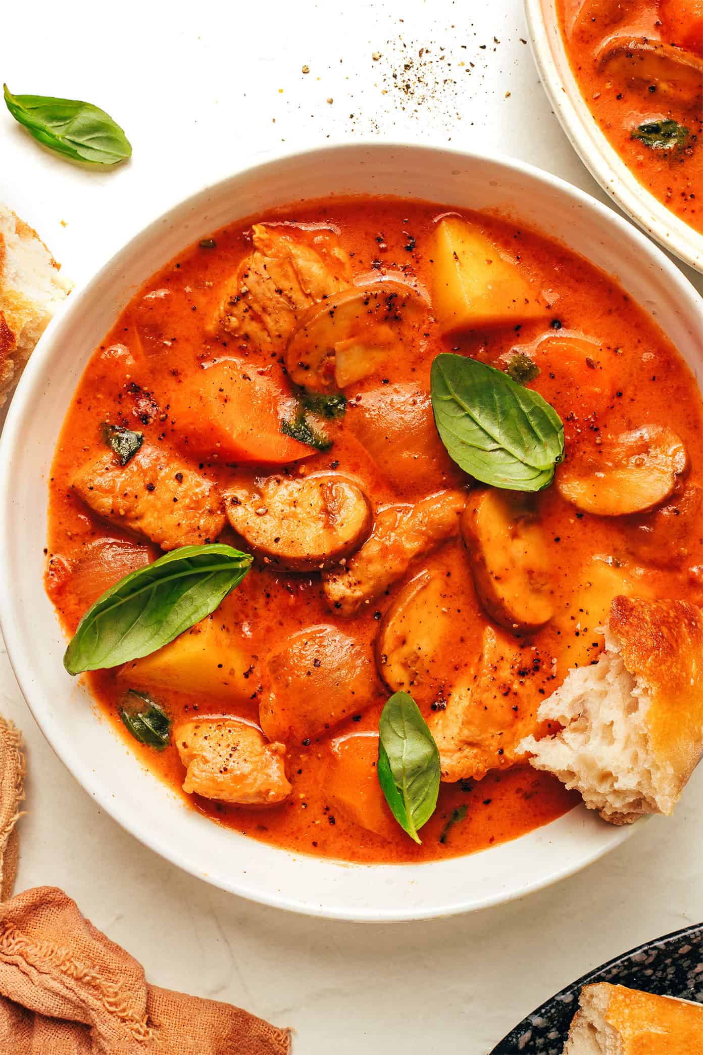 tomato basil chicken stew in bowl with bread